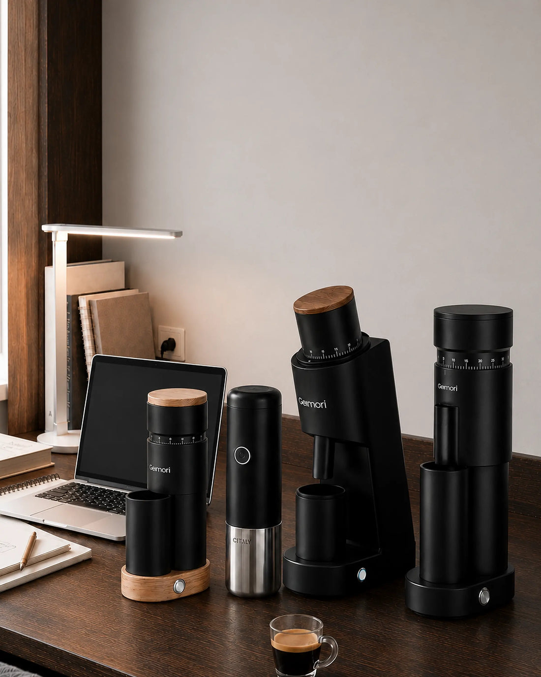 A set of black Mennip coffee brewing and grinding devices arranged on a wooden desk in a home office setting, alongside a laptop, lamp, and espresso cup.slider_item_QDe6nh
